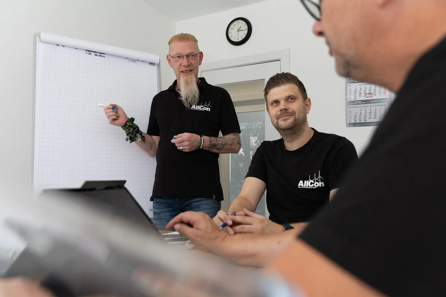 Kollege erläutert am Flipchart im Büro Hamburg